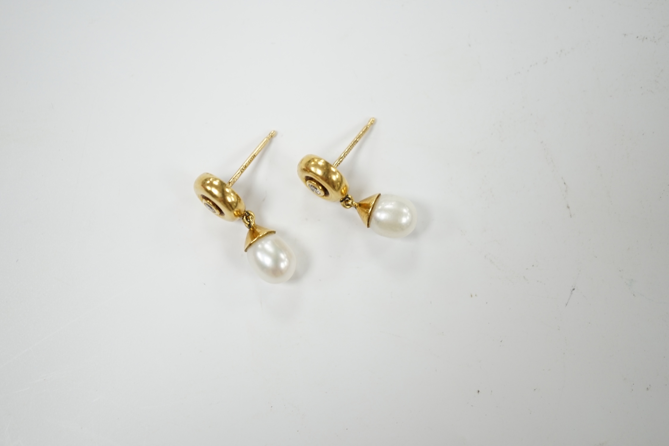 A modern pair of Boodles & Dunthorne 18ct gold, single stone cultured pearl and single stone diamond set drop earrings, lacking butterflies, 21mm, gross weight 5.1 grams. Condition - fair